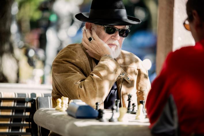 Gentleman playing chess outside