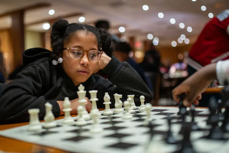 A girl concentrating on her chess game