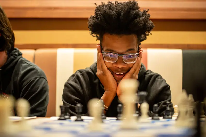 A young man playing chess and having fun